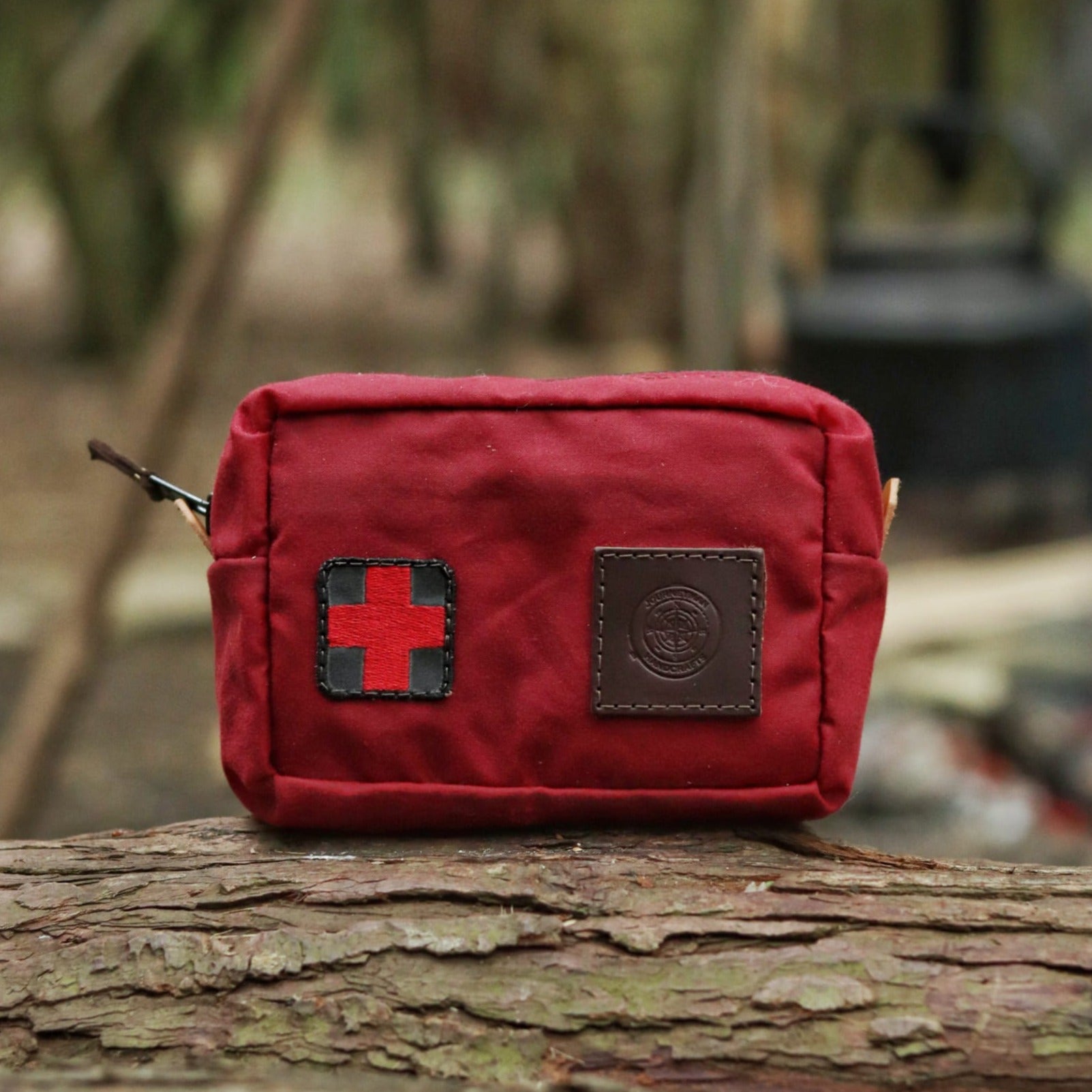  A red traditional wax canvas first aid kit belt pouch with a red cross and leather patch
