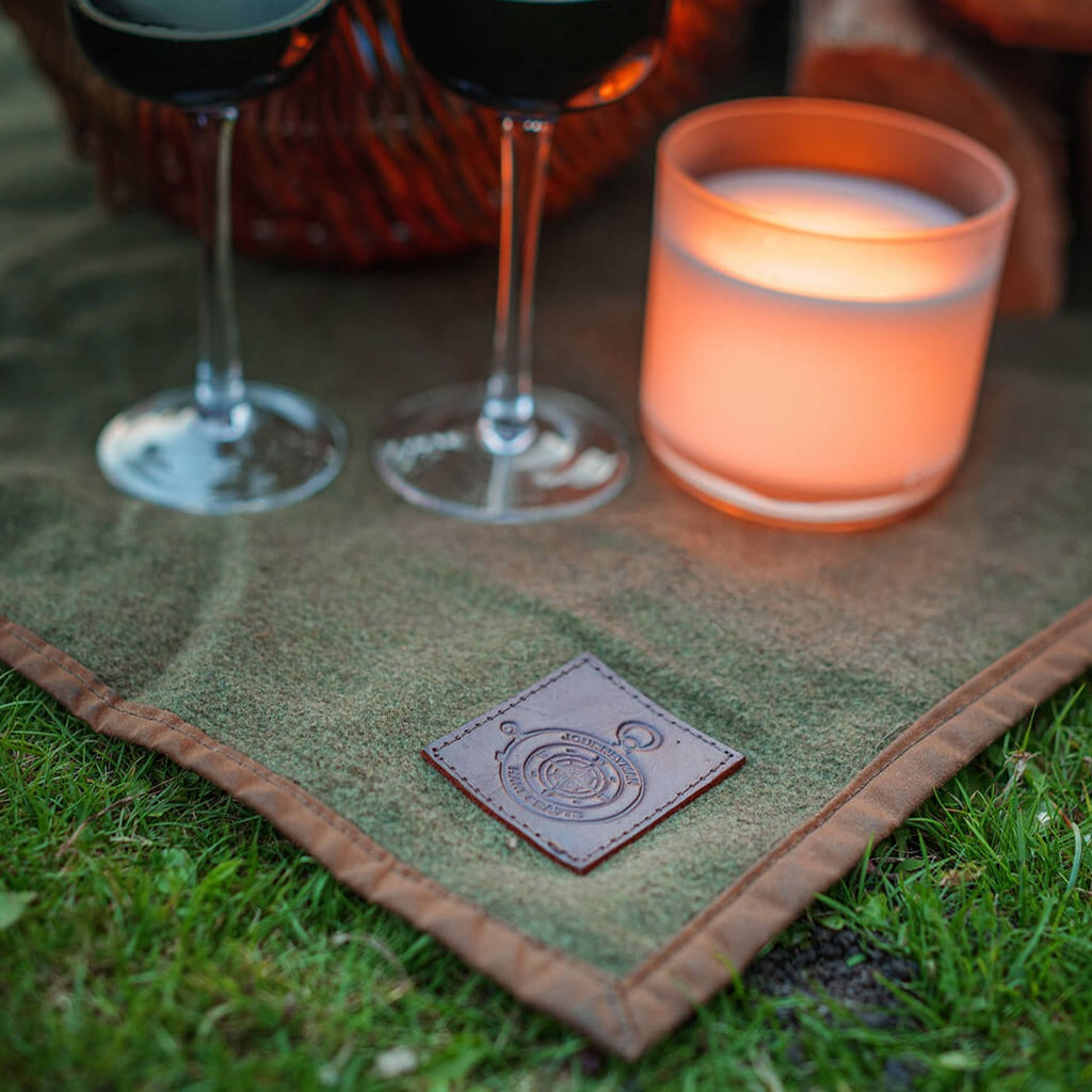 Red wine, cosy candle and a wool picnic blanket