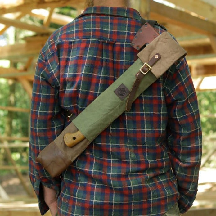 A man wearing an axe and bucksaw carry case for carrying tools in the woods