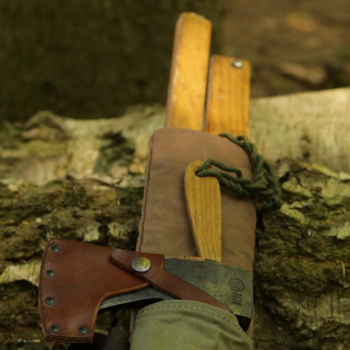 An axe and bucksaw inside a carry sleeve
