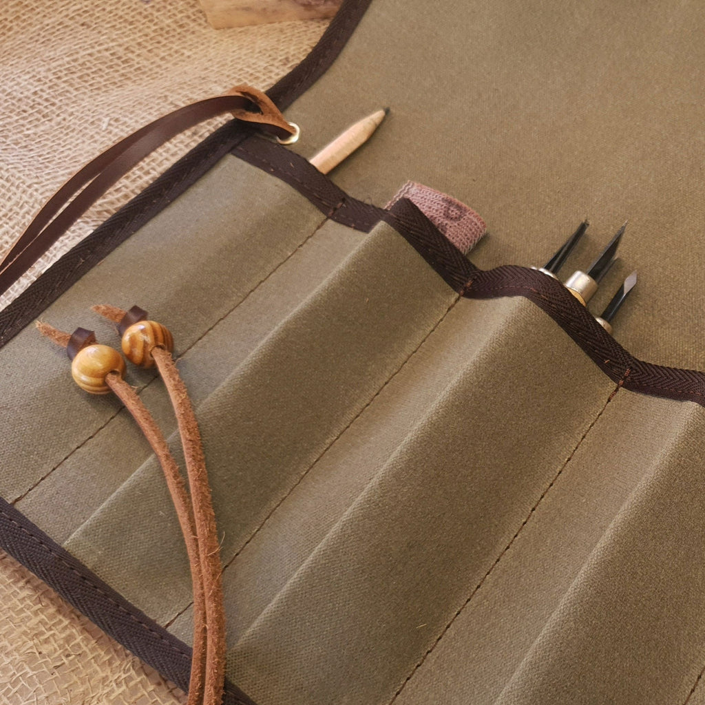 Green canvas tool roll, with leather ties and wooden toggles.