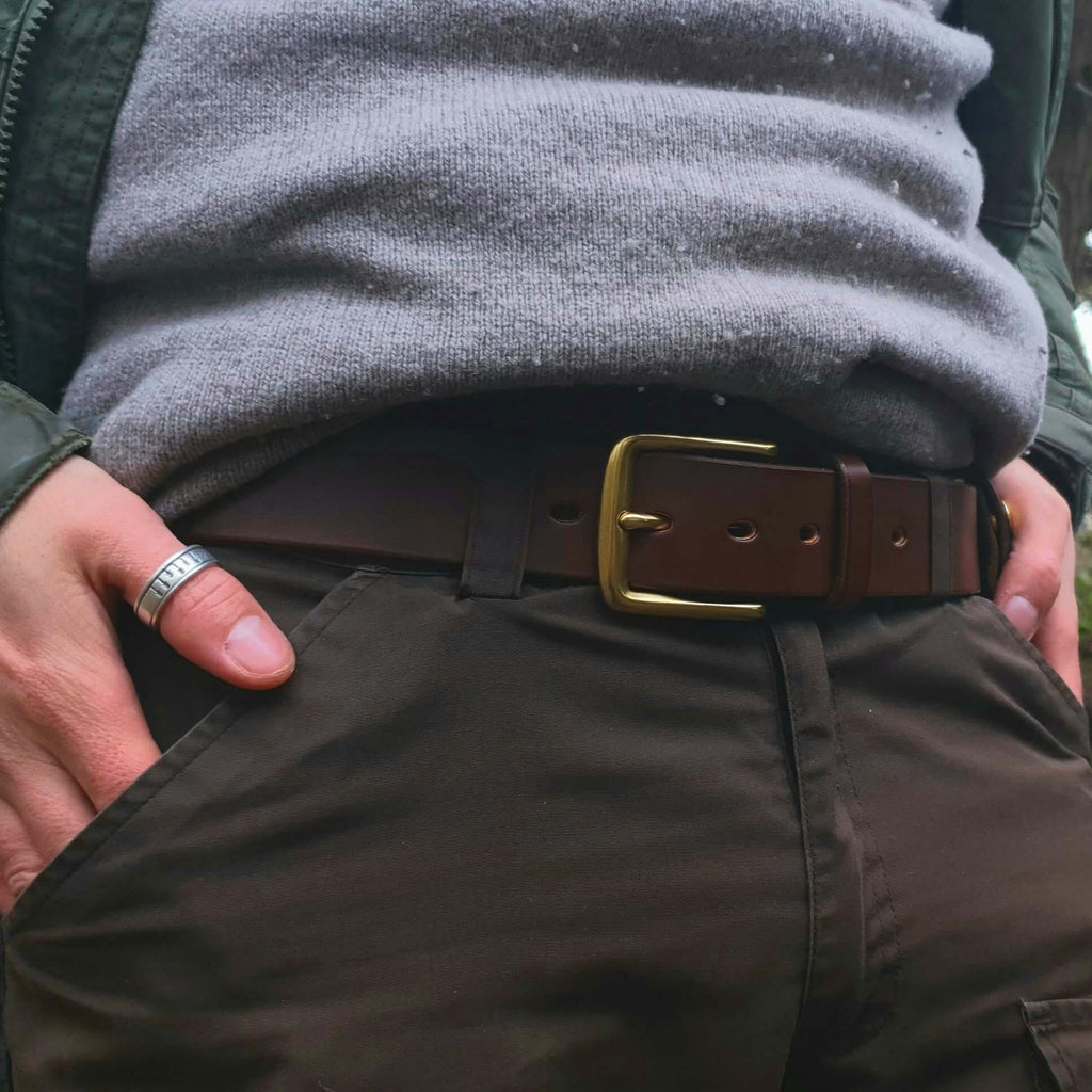A dark brown leather belt with a brass buckle