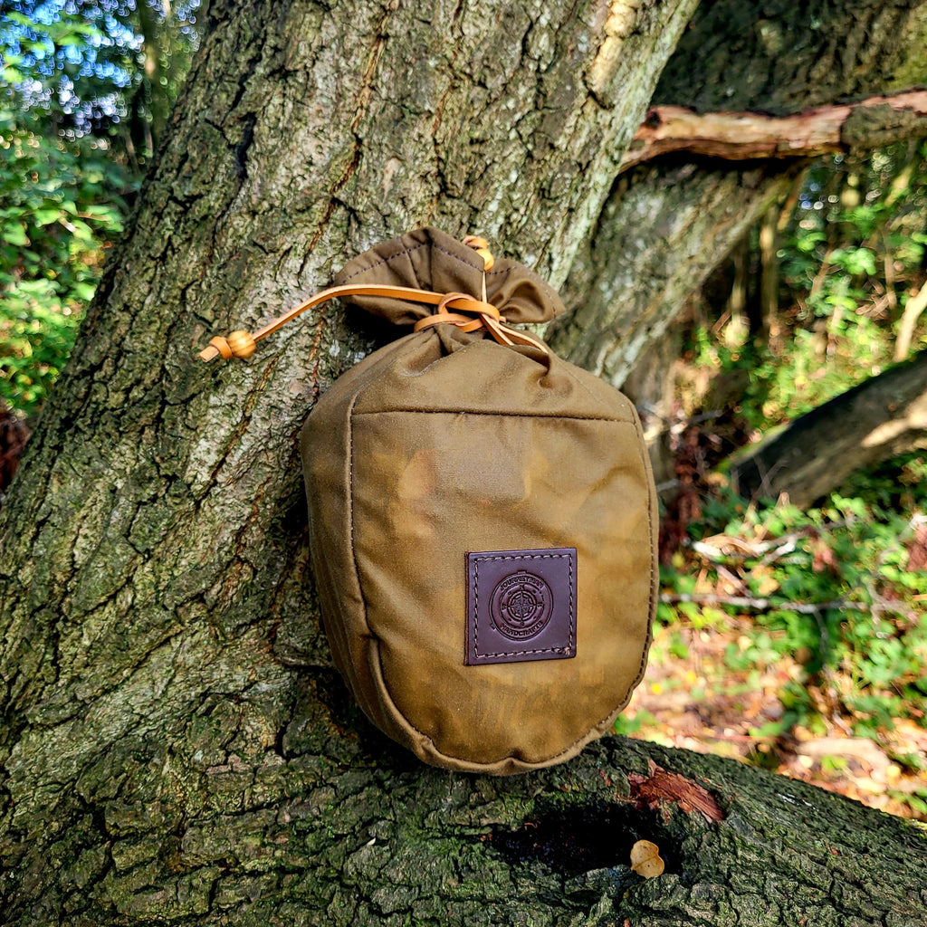 A wax canvas pouch for carrying flour for campfire cooking in the woods