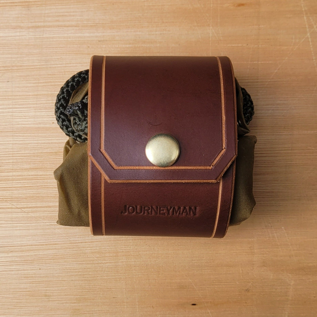 A folded forager dump pouch made from canvas and leather