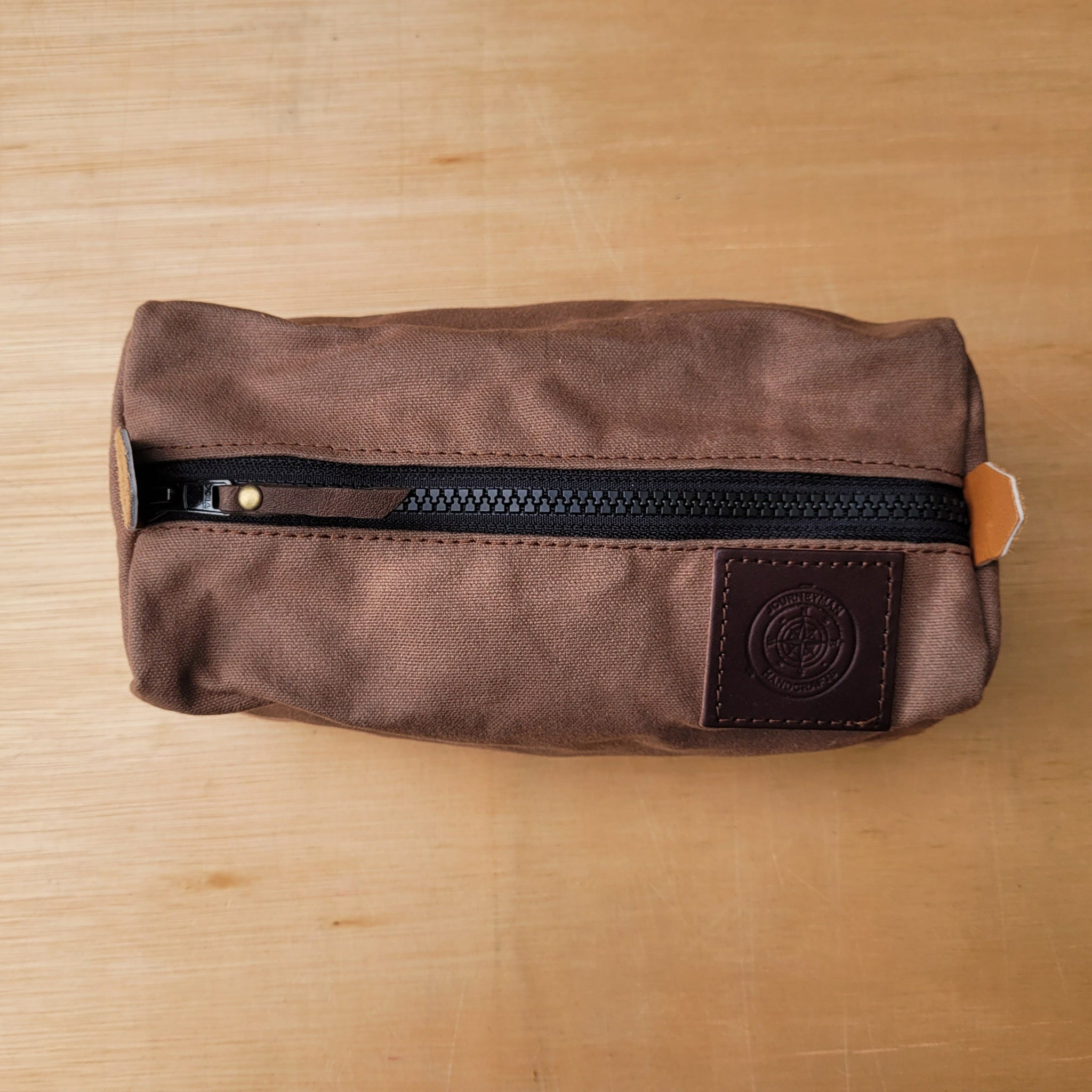 A brown wax canvas pouch for carrying tent pegs